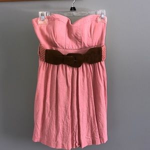 Short, pink, strapless dress with belt.